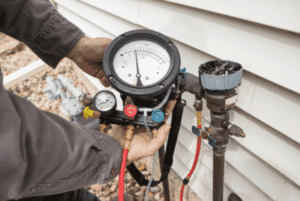 Technician performing a backflow preventer test on an irrigation system